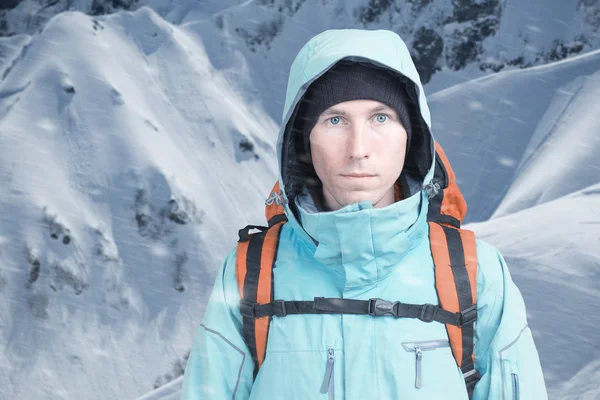 背景の高山で、カメラを見て登山家の男。クローズ アップの肖像画. — ストック写真