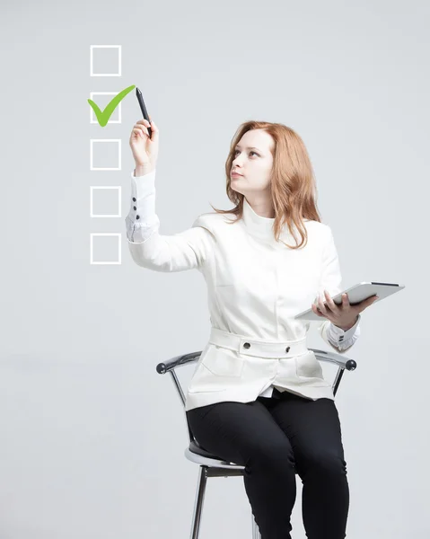 Junge Geschäftsfrau beim Ankreuzen der Checkliste. grauer Hintergrund. — Stockfoto