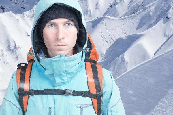 Homme alpiniste regardant la caméra, en arrière-plan de hautes montagnes. Gros plan portrait . — Photo