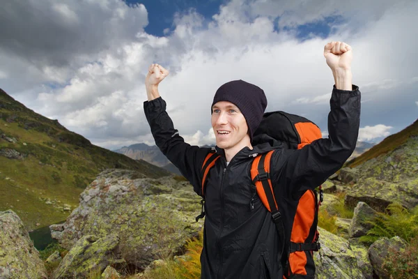 Uomo escursionista con le mani in alto in montagna . — Foto Stock