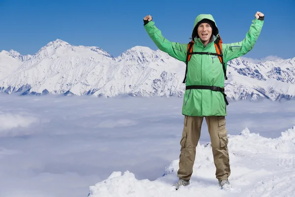 調達の腕を持つ男は幸せの男性登山家。背景高山に雲の上 . — ストック写真