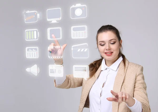 Frau drückt Multimedia- und Unterhaltungssymbole auf einen virtuellen Hintergrund — Stockfoto