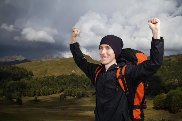 Uomo escursionista con le mani in alto in montagna . — Foto Stock