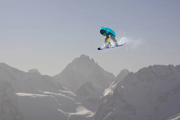 Cavaliere snowboard saltare sulle montagne. Sport di snowboard estremo . — Foto Stock