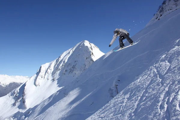 Snowboard cavalier sautant sur les montagnes. Sport extrême de snowboard . — Photo