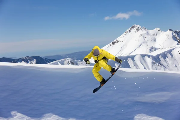 Cavaleiro de snowboard pulando em montanhas. Desporto de snowboard extremo . — Fotografia de Stock