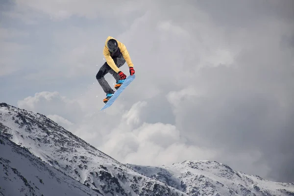 滑雪板骑手跳跃于群山之巅。极端的滑雪运动. — 图库照片