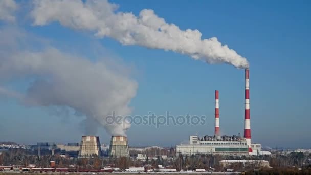 Теплоэлектростанция или завод с дымовыми трубами. Загрязняя дым в ясном голубом небе . — стоковое видео