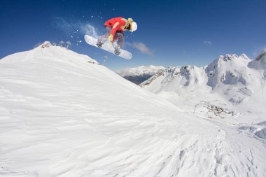 Dağlarda atlayan snowboard binicisi. Ekstrem snowboard serbest spor.