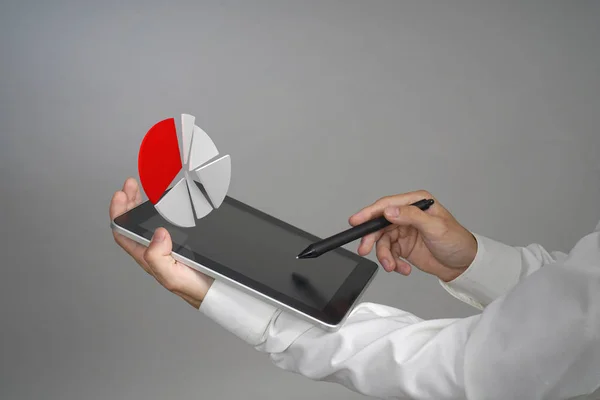 Pasta grafiği ile çalışan bir tablet bilgisayar, bütçe planlama veya mali istatistikleri için uygulama üzerinde Beyaz tişörtlü adam. — Stok fotoğraf