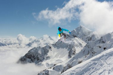 Dağlarda atlayan snowboard binicisi. Ekstrem snowboard serbest spor.