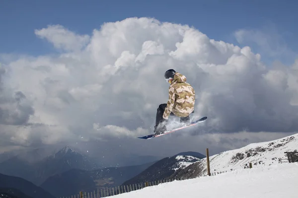 Cavaleiro de snowboard pulando em montanhas. Esporte de freeride de snowboard extremo. — Fotografia de Stock