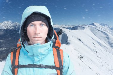 Dağcı adam arka plan yüksek dağlarda kamera bakıyor. Yakın çekim portre.