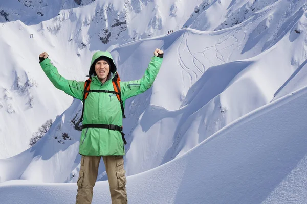 Szczęśliwy, mężczyzna alpinista z rękoma wzniesionymi nad głową. W tle wysokie góry. — Zdjęcie stockowe