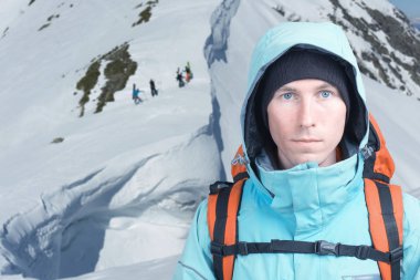 Climber erkeği kış dağlar, yokuş yukarı freeride içinde belgili tanımlık geçmiş için yürüyüş snowboard duruyor.