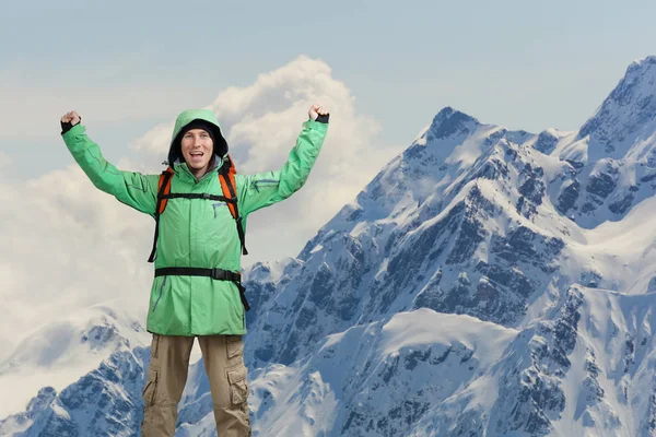 Alpinista varón feliz con los brazos levantados sobre la cabeza. Al fondo las altas montañas . — Foto de Stock