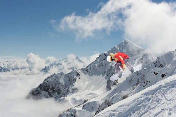 Cavaleiro de snowboard pulando em montanhas. Desporto de snowboard extremo . — Fotografia de Stock
