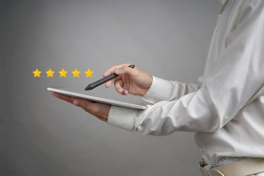 Beş yıldızlı değerlendirme veya sıralaması, kavram kıyaslama. Tablet Pc ile adam değerlendiriyor Servisi, otel, Restoran