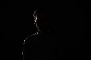 T-shirt genç adam koyu arka plan üzerinde.