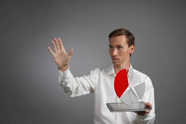 Pasta grafiği ile çalışan bir tablet bilgisayar, bütçe planlama veya mali istatistikleri için uygulama üzerinde Beyaz tişörtlü adam. — Stok fotoğraf