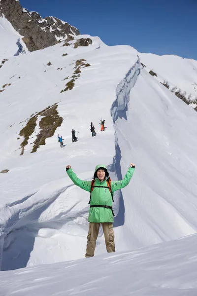 Heureux alpiniste masculin avec les bras levés au-dessus de la tête. En arrière-plan les hautes montagnes . — Photo