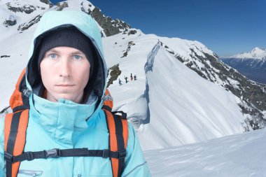 Climber erkeği kış dağlar, yokuş yukarı freeride içinde belgili tanımlık geçmiş için yürüyüş snowboard duruyor.
