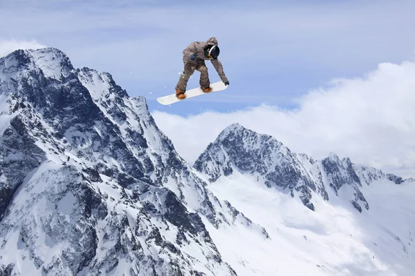 スノーボード ライダーが山にジャンプします。極端なフリーライド スポーツ. — ストック写真
