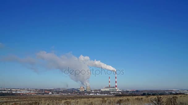 Wärmekraftwerk oder Fabrik mit rauchenden Schornsteinen. Verschmutzender Rauch in den strahlend blauen Himmel. — Stockvideo