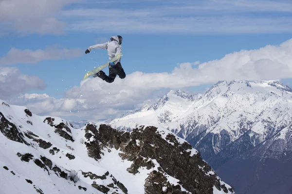 Um snowboarder voador nas montanhas. Desporto extremo. — Fotografia de Stock