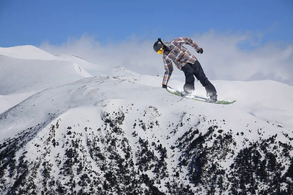 Snowboard rider saltando en las montañas. Deportes extremos de snowboard . —  Fotos de Stock