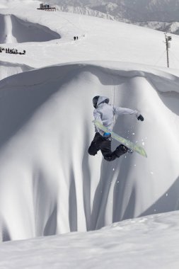 Dağlarda atlayan snowboard binicisi. Ekstrem snowboard serbest spor.