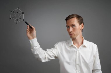 Genç erkek bilim adamı atomun bir modeliyle çalışıyor..