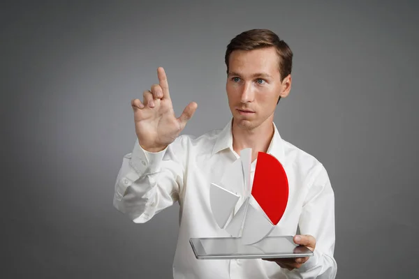Человек в белой рубашке работает с круговой диаграммой на планшетном компьютере, приложением для бюджетного планирования или финансовой статистикой . — стоковое фото