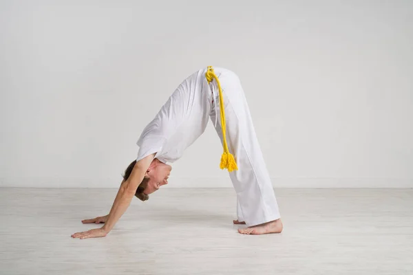 L'uomo in abiti sportivi bianchi fa yoga . — Foto Stock