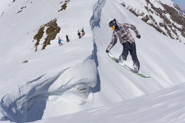 Volando snowboarder en las montañas. Extremo deporte de invierno. — Foto de Stock