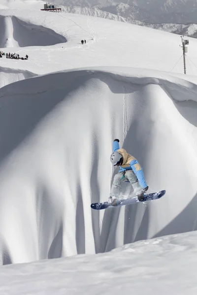 Létající snowboardista na horách. Extrémní zimní sport. — Stock fotografie