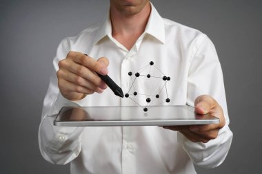 Genç erkek bilim adamı atomun bir modeliyle çalışıyor..