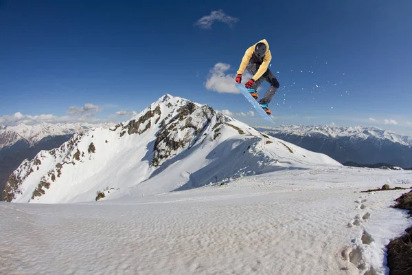 Repülő snowboardos a hegyekben. Extrém téli sport. — Stock Fotó