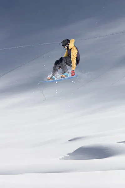 Flygande snowboardåkare på fjället. Extrem vinter sport. — Stockfoto