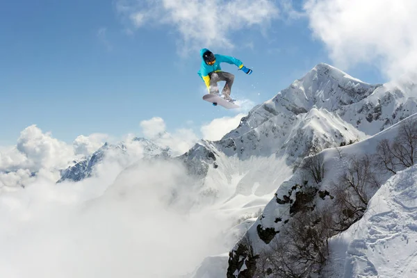 Snowboard rider skákání na horách. Extrémní snowboard sport. — Stock fotografie