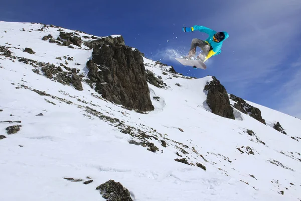 Sport d'hiver extrême. Snowboarder sautant dans les montagnes enneigées . — Photo
