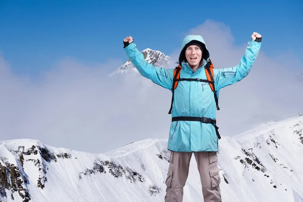 Mutlu erkek dağcı adam kaldırdı kollarını. Arka plan yüksek dağlarda bulutların üstünde . — Stok fotoğraf