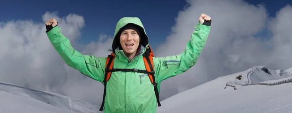Ευτυχισμένος αρσενικό ορειβάτης άνθρωπος με υψωμένα χέρια. Σε φόντο ψηλά βουνά πάνω από τα σύννεφα . — Φωτογραφία Αρχείου