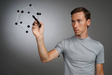 Genç adam molekül modeli ile çalışır.