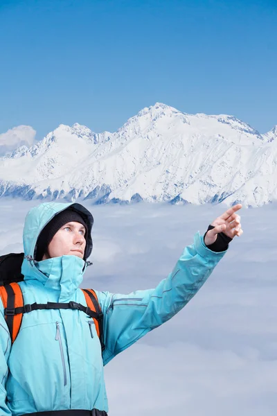 最盛期には、冬の山の風景に立っている指している登山家. — ストック写真