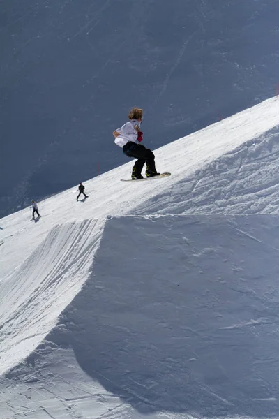 SOCHI, RUSSIA - MARCH 22, 2014: Snowboarder jumps in Snow Park, ski resort — Stock Photo, Image