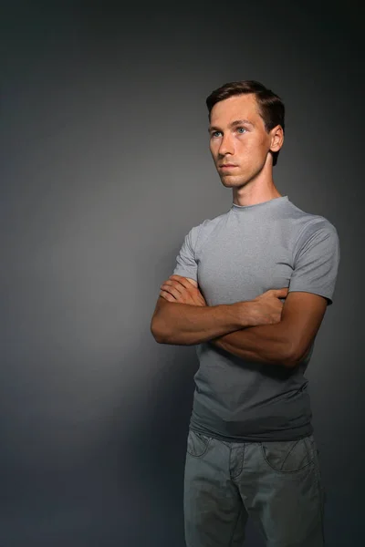 Portrait d'homme caucasien debout avec les mains croisées sur fond gris . — Photo