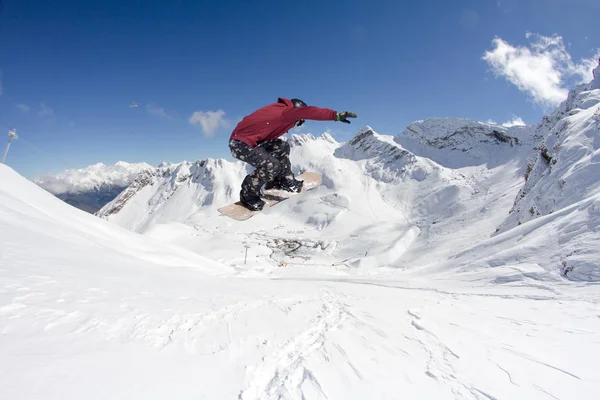 Snowboarder springt in den Bergen, Winter Extremsport. — Stockfoto