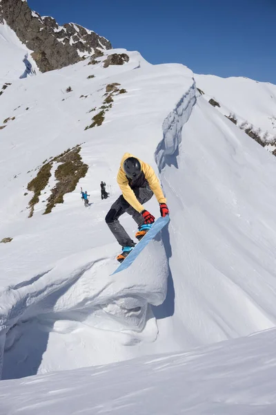 Snowboarder salta en las montañas, deporte extremo de invierno . — Foto de Stock