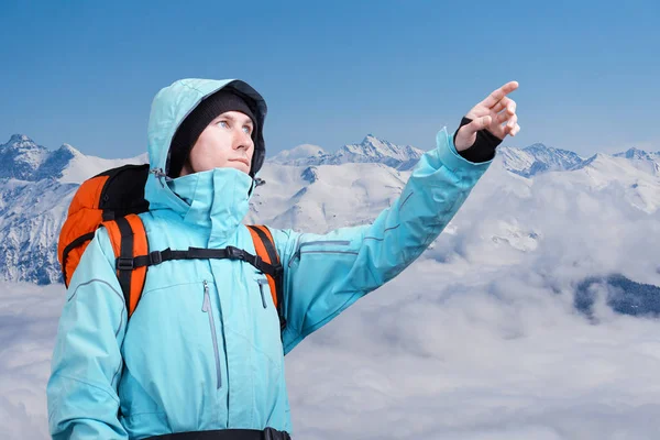 最盛期には、冬の山の風景に立っている指している登山家. — ストック写真